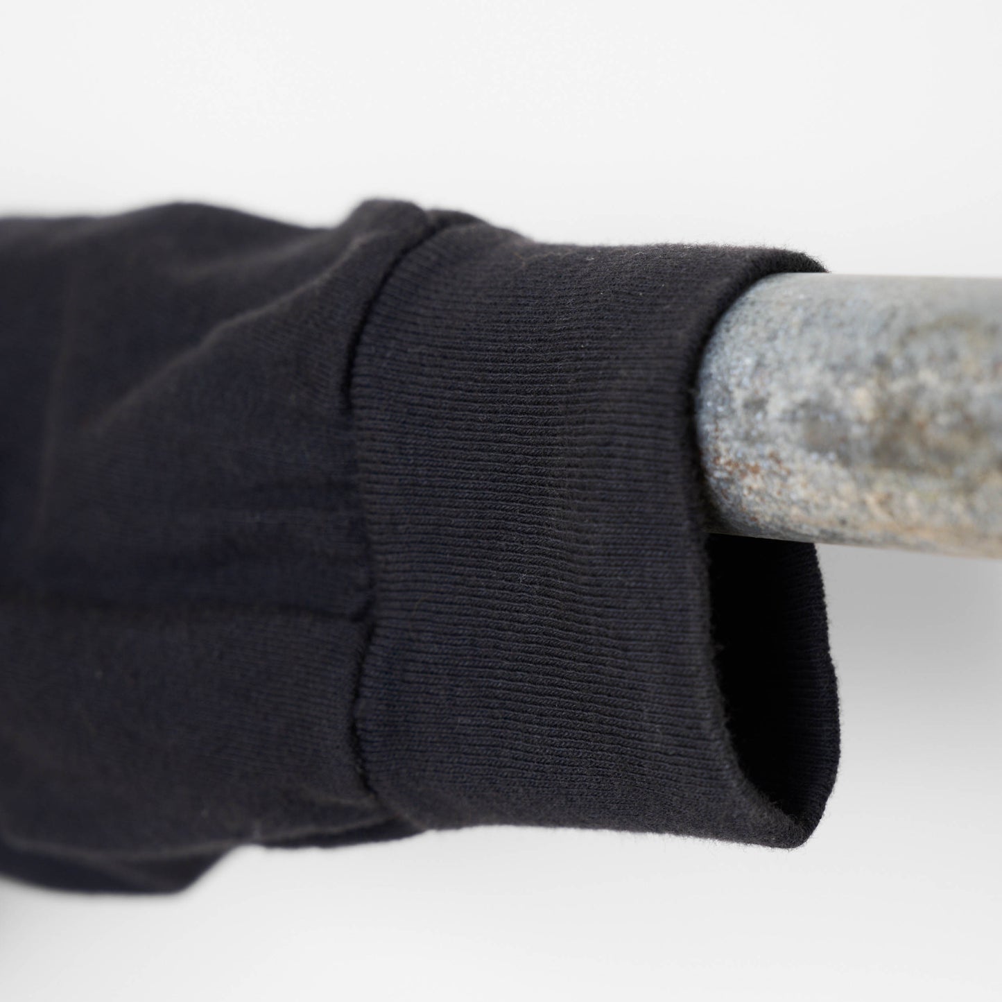 Close up view of one long sleeve of black shirt on a hangar.