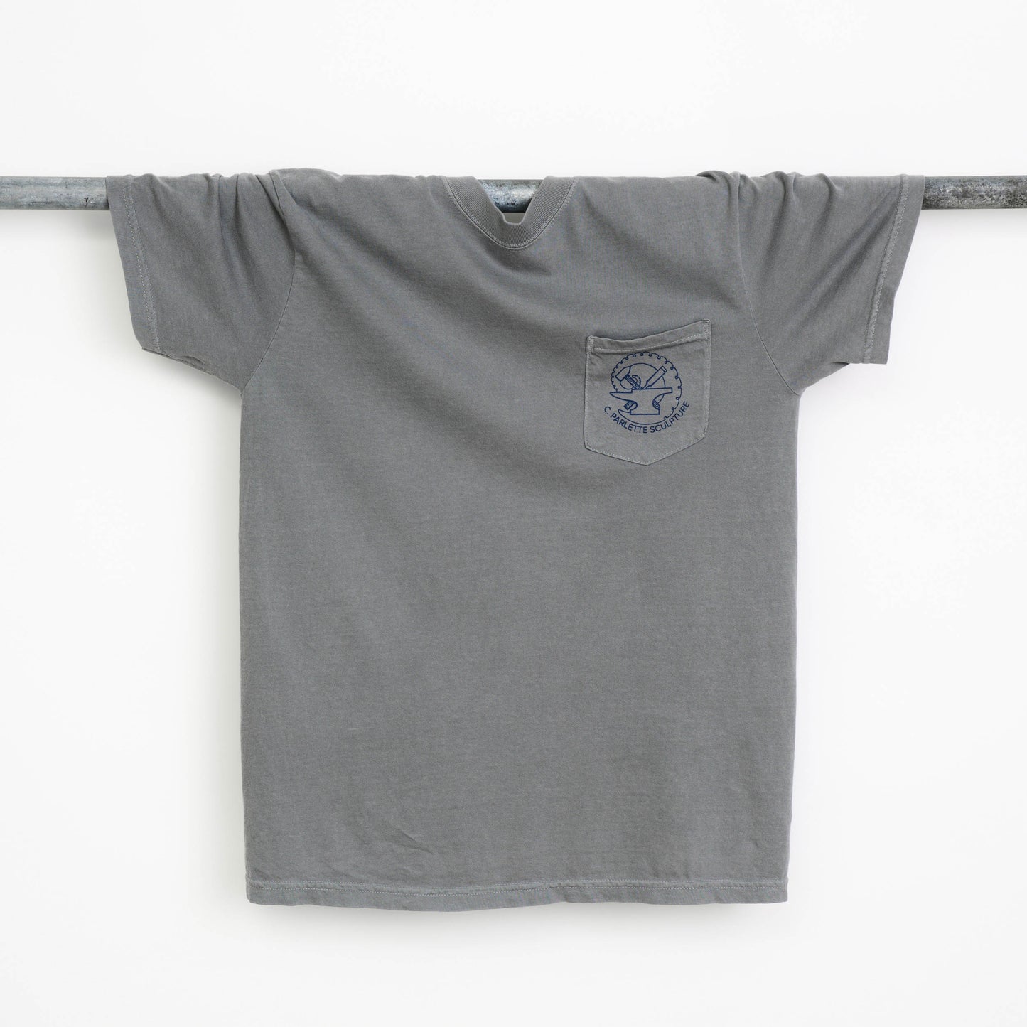 Gray t-shirt with a logo on a metal rod against a white background.