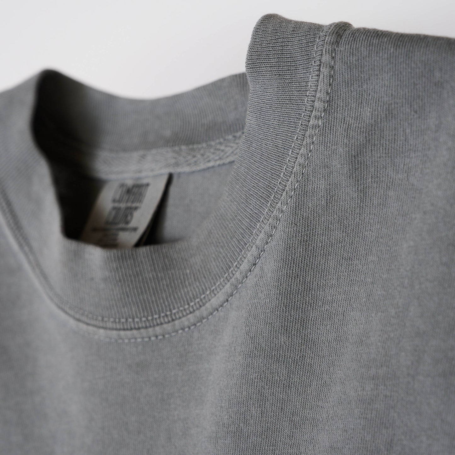 Close-up view of crew neck collar of gray t-shirt.