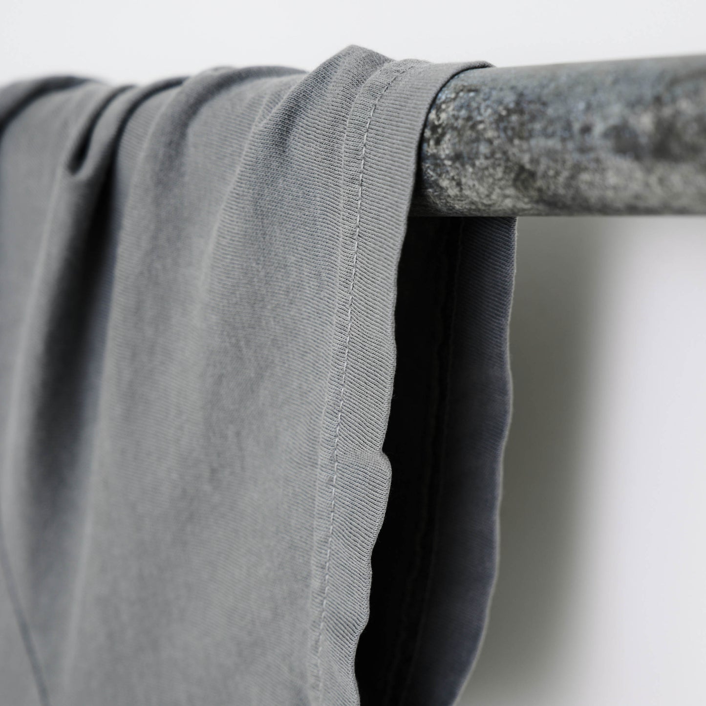 Close-up view of one sleeve of the t-shirt with white stitching.