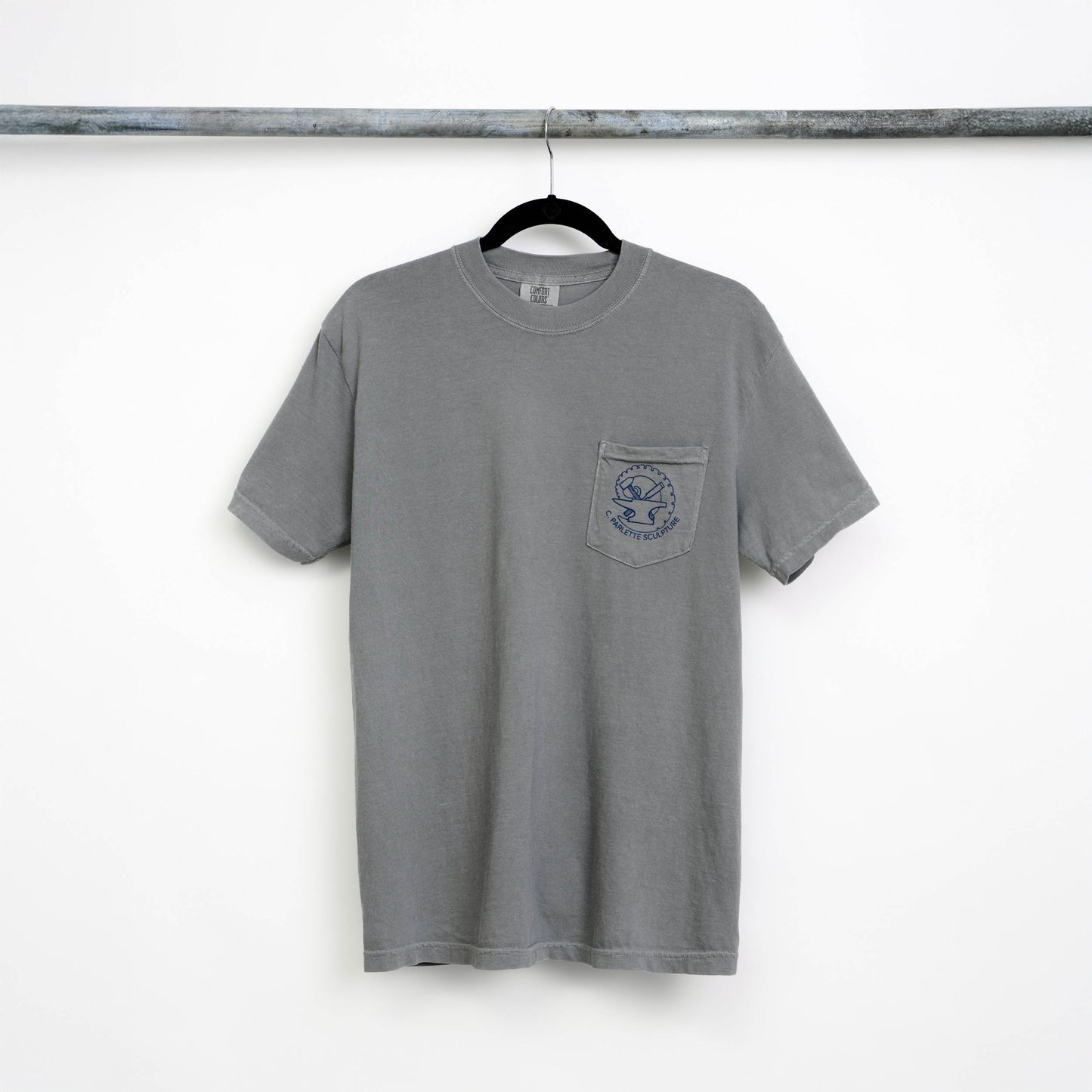 Gray, short-sleeved t-shirt on a hangar with a front pocket and blue logo on the pocket.