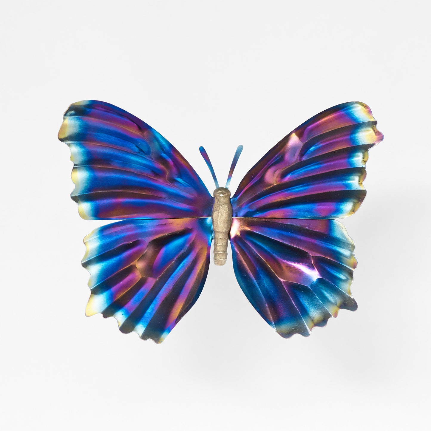 Front view of a butterfly sculpture with a silver body and iridescent blue, purple and gold wings and antennae.